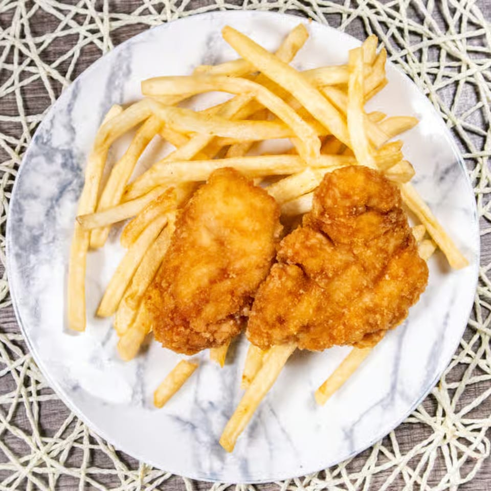 Two crispy fried chicken tenders and a pile of golden french fries on a marble plate.