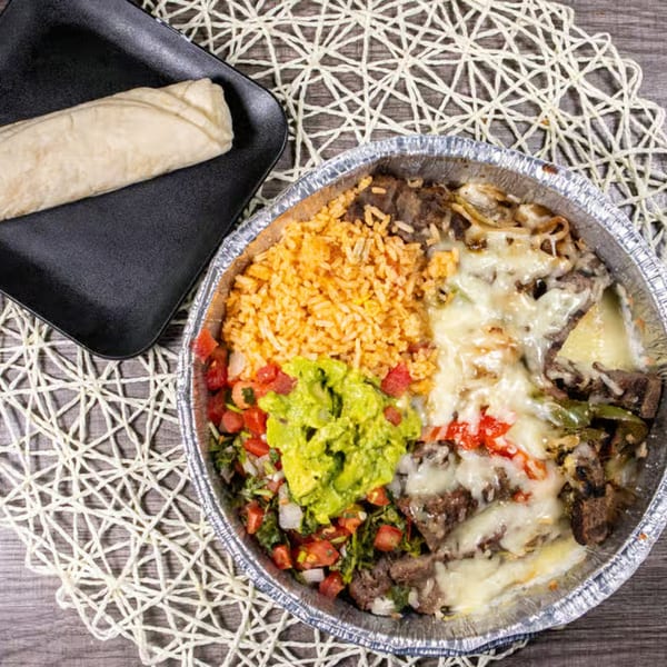A Mexican cafe meal with rice, guacamole, pico de gallo, and cheesy steak in a foil container.